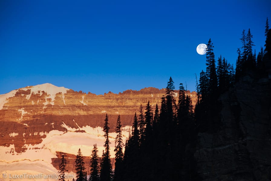 The full moon above Lake Louise sinks lower in the morning sky