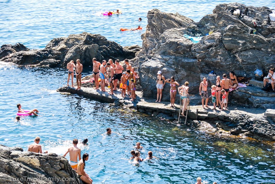 Lots of people go swimming off the rocks in Manarola, Italy