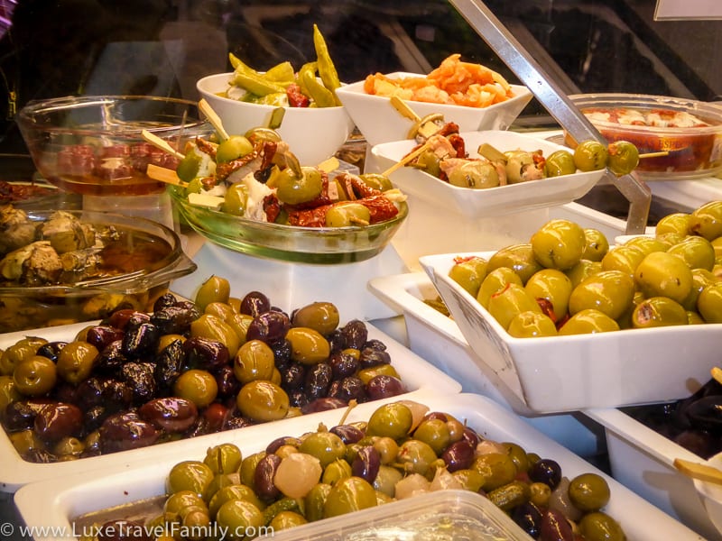 Bowls of olives, onions and peppers in the display case at at Conserves Gloria