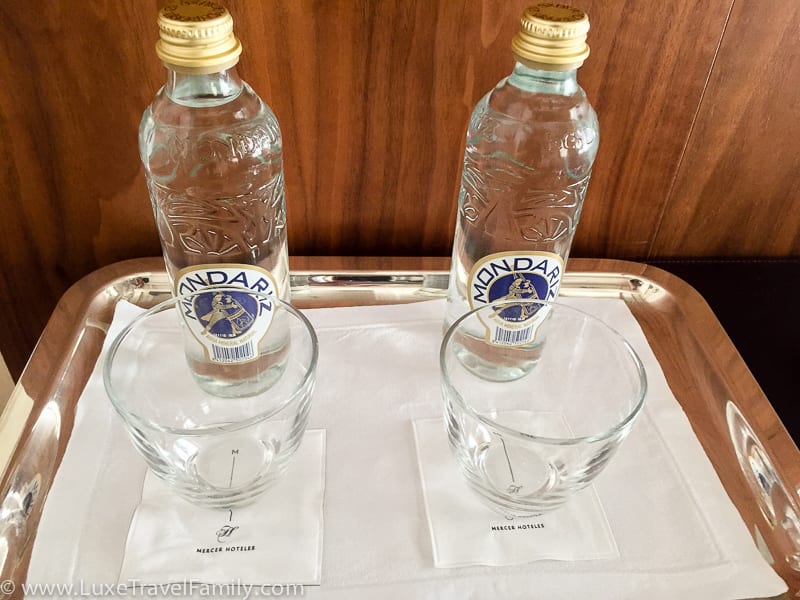 Two glass bottles and glasses in a guest room at the Mercer Hotel Barcelona