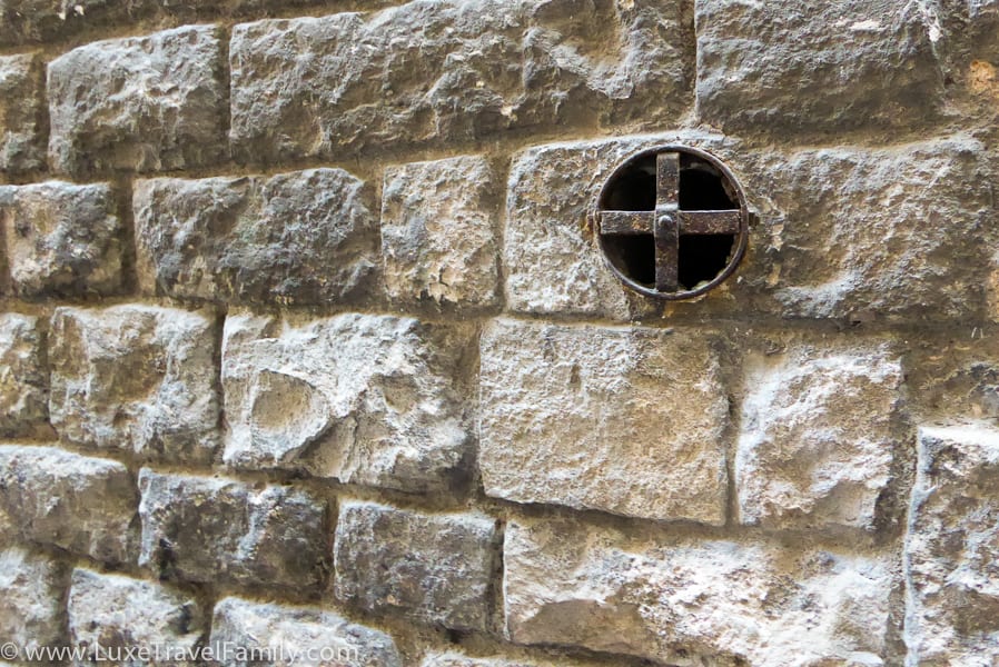 A circular copper hole in a stone wall in the Gothic Quarter, Barcelona