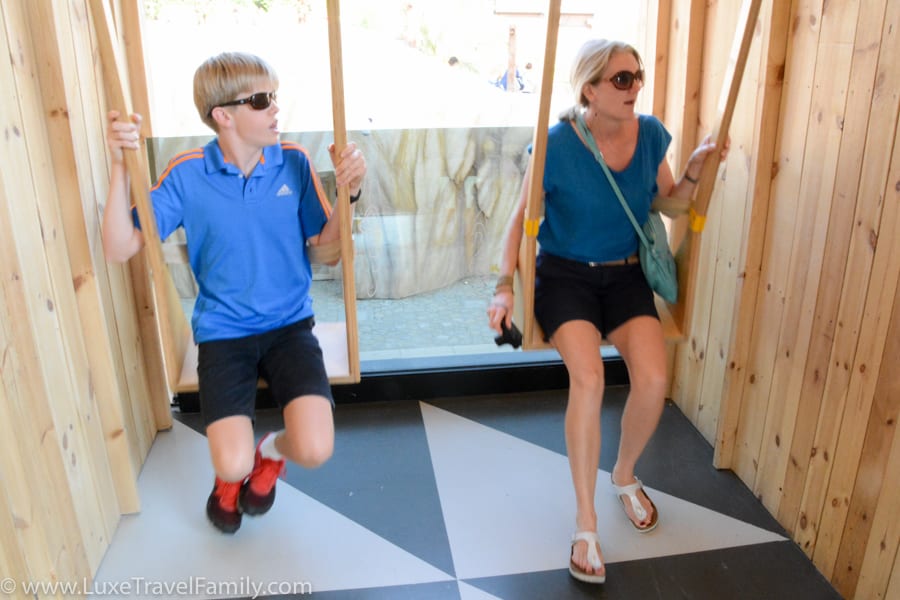 A woman and boy on wooden swings at the Estonia Pavilion, Expo 2015 Milan