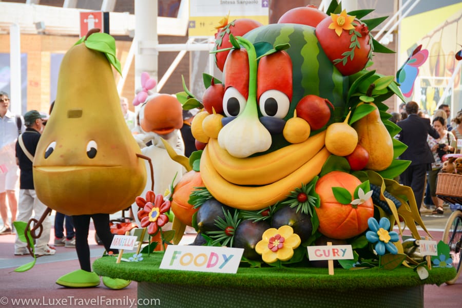 Foody, the Expo 2015 mascot is a colourful creature with two bananas for a mouth and a watermelon for a head.