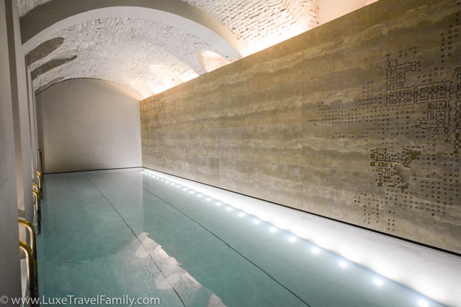 A 45 foot indoor pool with stone walls and overhead arches at Four Seasons Hotel Milano