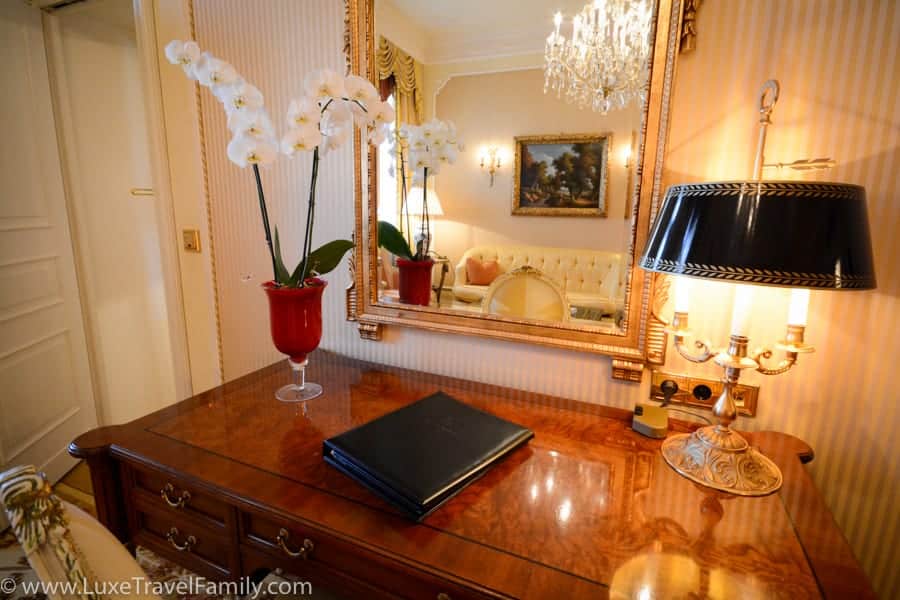 Desk, sofa and chandelier in a guest room at Hotel Imperial