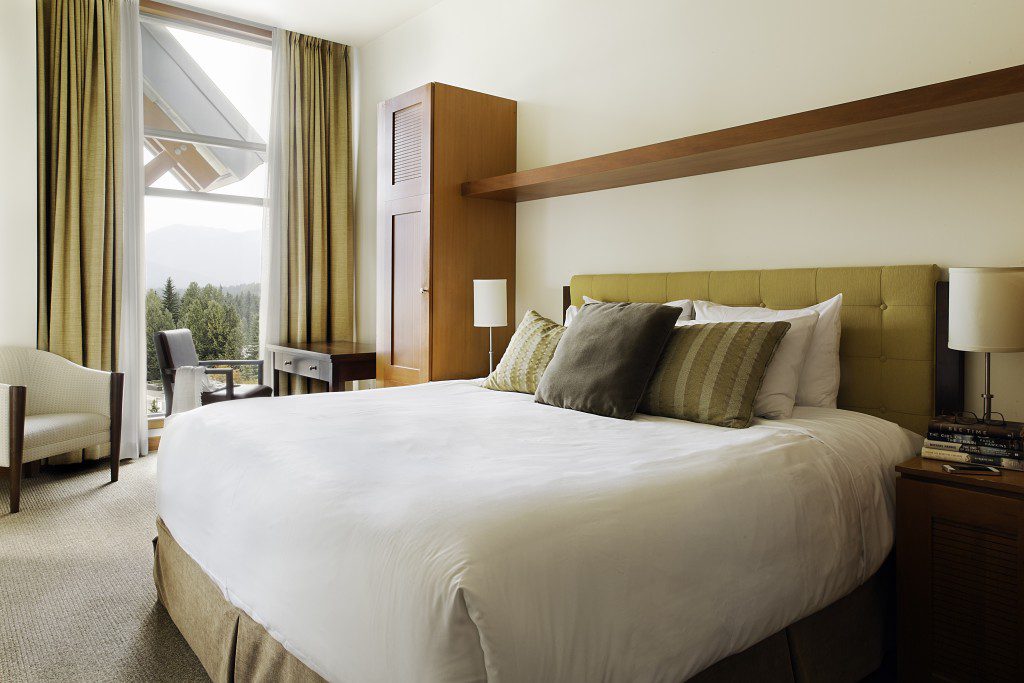 A king or queen-size bed in a bedroom at Pan Pacific Whistler Village Centre