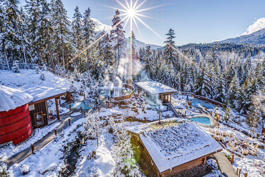 Scandinave Spa Whistler spa pools, snow-covered trees and buildings.