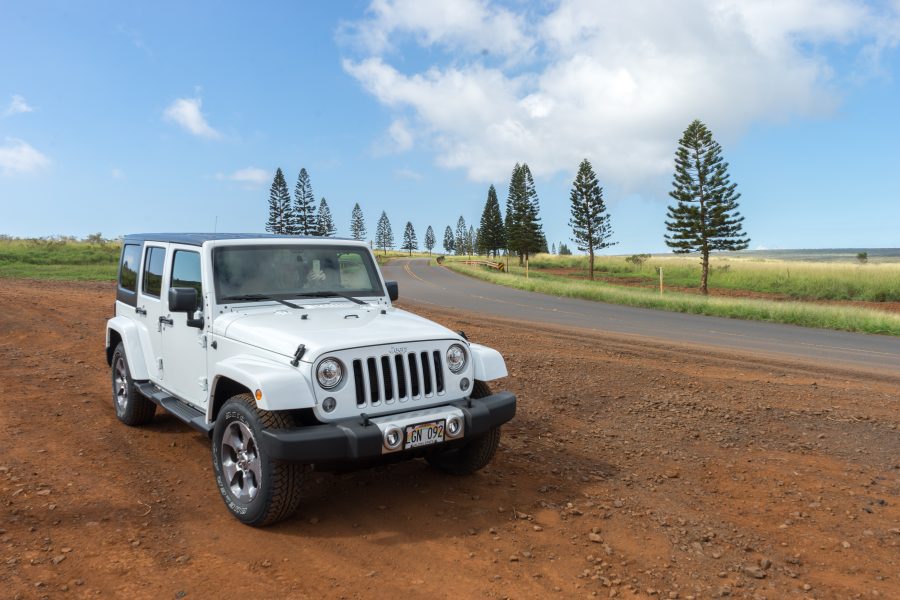 white jeep parked beside a paved two lane road