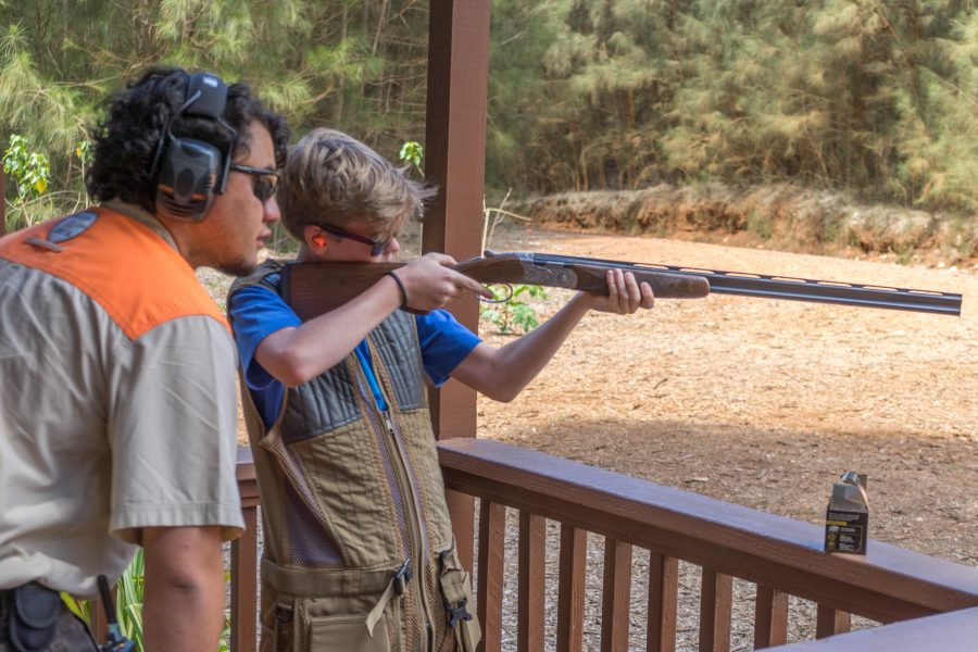 Teenage boy and teacher at Lanai's clay shooting range