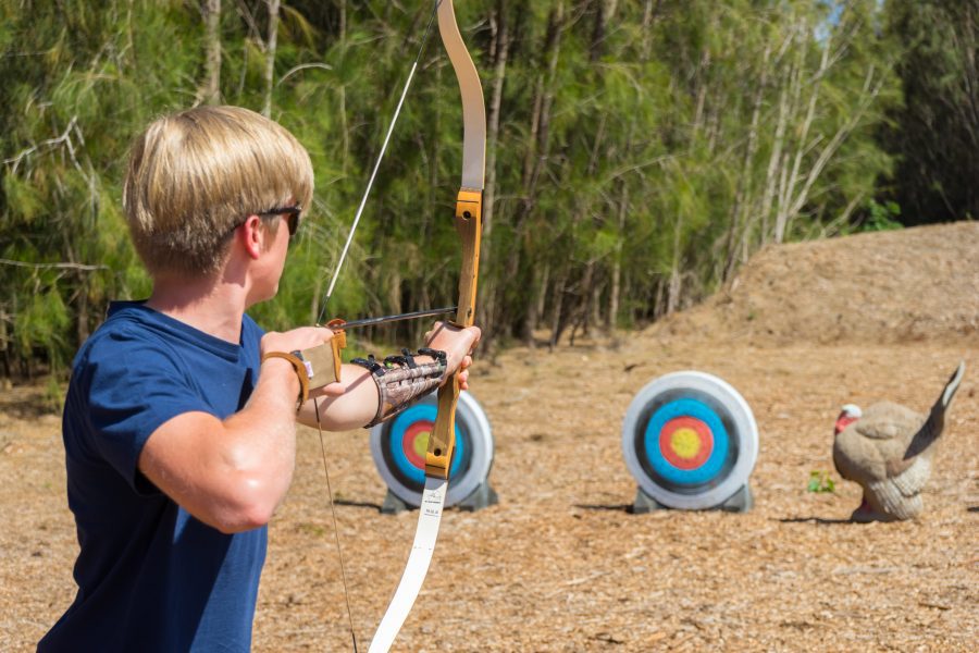 Teenage boy practicing archery on lanai