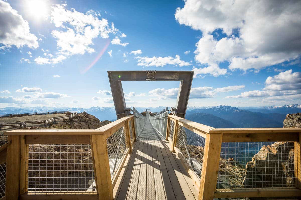 Cloudraker suspension bridge up high in a blue sky and puffy white clouds
